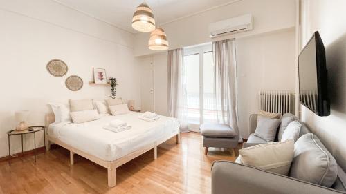 biała sypialnia z łóżkiem i kanapą w obiekcie Boho Chic 2BR Apartment in the Center of Athens w Atenach