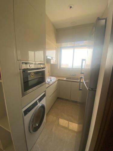 a small kitchen with a stove and a refrigerator at Maxxvalue Apartment Hiranandani Powai - RH5 in Mumbai