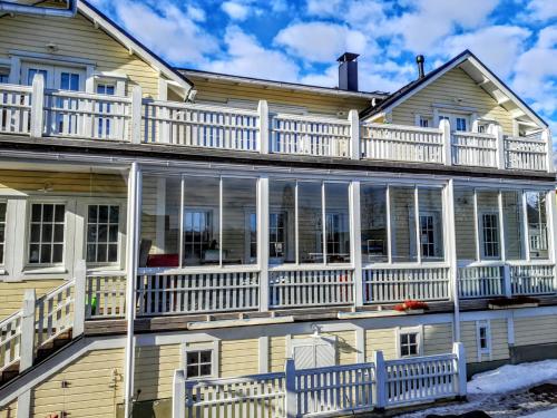 una grande casa con portici bianchi e balconi di TurusenSaha Guesthouse a Oulu