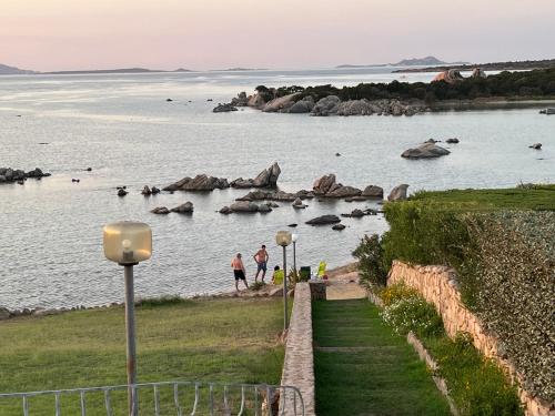 two people walking on the shore of a body of water at CASA SIBILLA bi-locale con terrazza a 60 metri dal mare in Marinella
