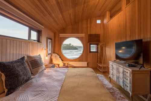 ein Schlafzimmer mit einem Bett und einem TV in einem Zimmer in der Unterkunft Bledford Chiloé in Castro