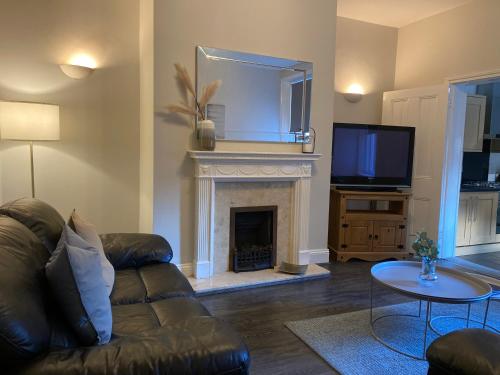 a living room with a couch and a fireplace at Alexander Apartments Jesmond in Newcastle upon Tyne