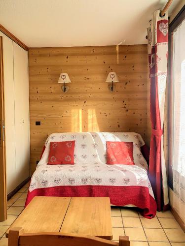 - une chambre avec un lit et un mur en bois dans l'établissement SH104 - Studio 4 pers centre des Carroz, aux Carroz d'Arâches