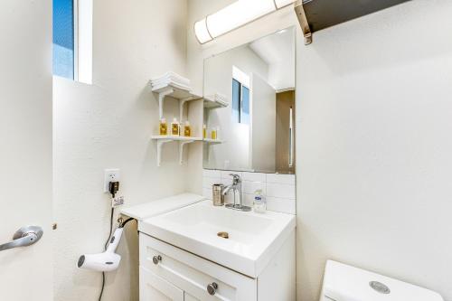 a white bathroom with a sink and a mirror at Plant Your Feet in Phoenix