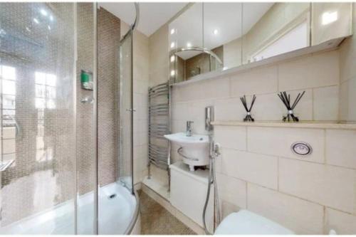 a bathroom with a tub and a sink and a toilet at 9 Brentwood Lodge in London