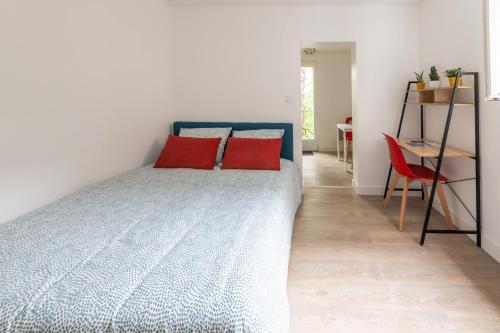 um quarto com uma cama com almofadas vermelhas em Terrasse des Loges em Rennes