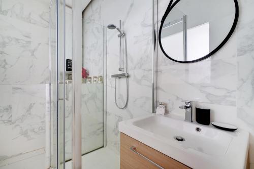 a bathroom with a sink and a shower with a mirror at CMG - Charmant et cosy appartement 4 Pax - Bastille in Paris