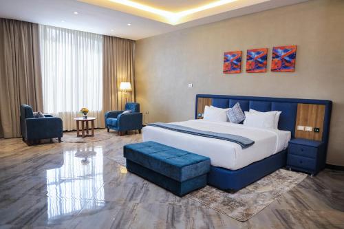 ein Hotelzimmer mit einem großen Bett und einem Wohnzimmer in der Unterkunft South Gate Hotel Apartment in Addis Abeba