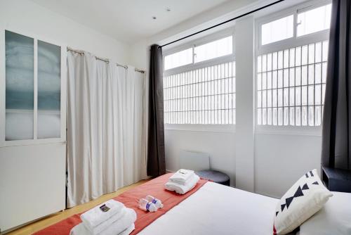 パリにあるCMG - Charmant et cosy appartement 4 Pax - Bastilleのベッドルーム1室(ベッド1台、大きな窓付)