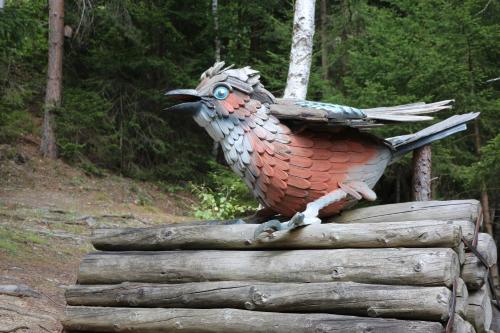 a statue of a bird sitting on a log at Sun Apartments - with Dolomiten Panorama in Lienz