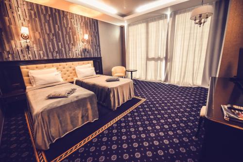 a hotel room with two beds and a window at Hotel Spa Ice Resort in Timişoara