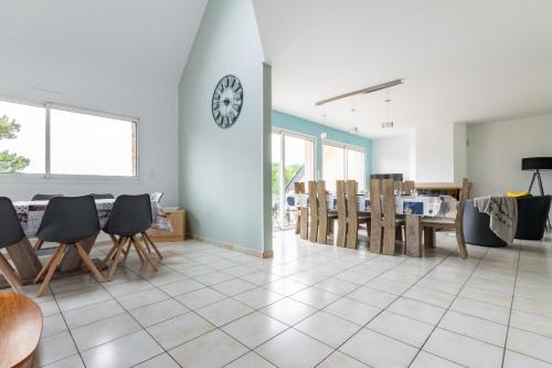 une salle à manger avec une horloge murale dans l'établissement Magnifique maison colorée avec jacuzzi - La Rose des Vents, à Arzon