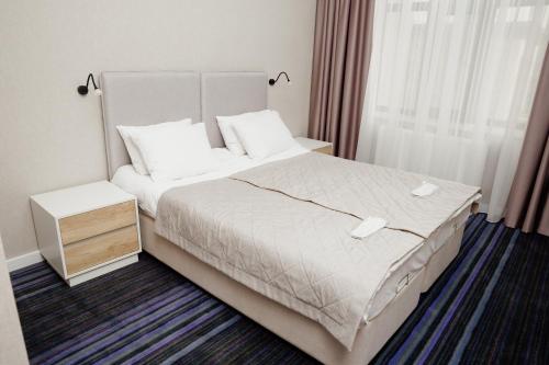 Habitación de hotel con cama y ventana en AMINA HOTEL en Astaná