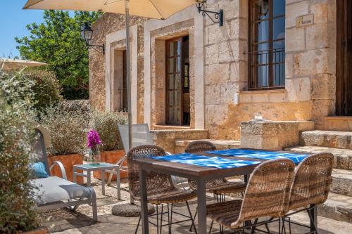 a table with chairs and an umbrella on a patio at Agroturismo Son Siurana in Alcudia