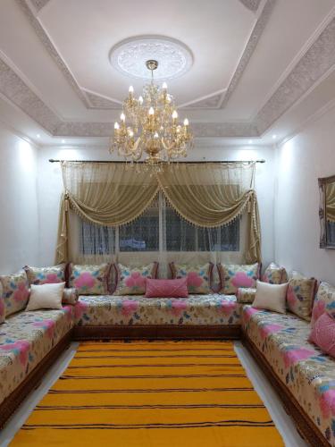 sala de estar con sofá y lámpara de araña en Majorelle appartement, en Fez