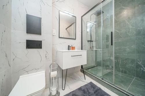 a bathroom with a shower and a sink and a tub at Style apartment studio Kabeny in Michalovce