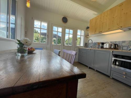 une cuisine avec un comptoir en bois dans une pièce dans l'établissement Charmante petite maison avec jardin plage des vieilles, à La Croix