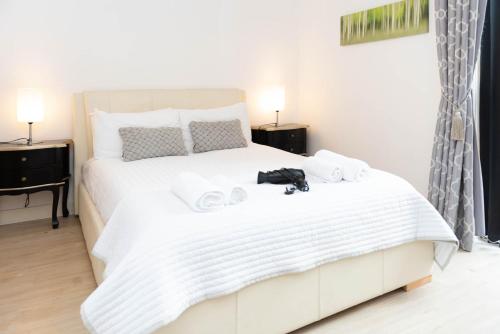 a bedroom with a white bed with towels on it at City Stay Apartments - Vizion in Milton Keynes