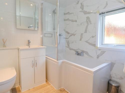 a bathroom with a shower and a tub and a sink at Fell Foot Lodge in Windermere