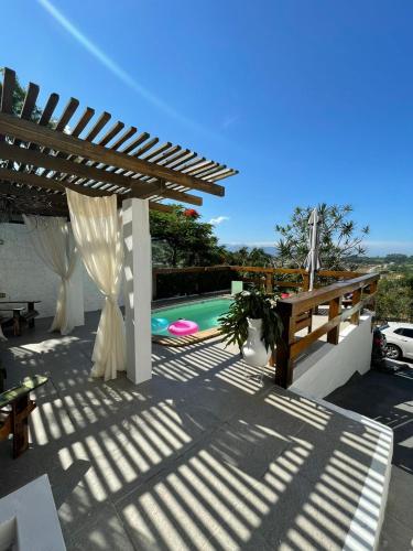 a patio with a pergola and a swimming pool at Mediterrâneo Flat Praia da Gamboa- Cabanas da Candoca in Garopaba