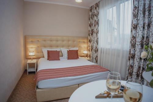 a hotel room with a bed and two tables with wine glasses at Hotel&Restaurant Premium Club in Yaremche