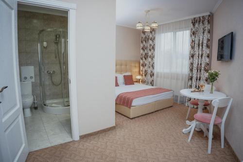a bedroom with a bed and a shower and a table at Hotel&Restaurant Premium Club in Yaremche