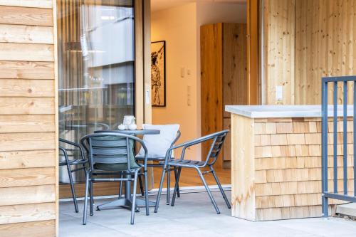 a patio with chairs and a table on a porch at Huus123 in Au im Bregenzerwald