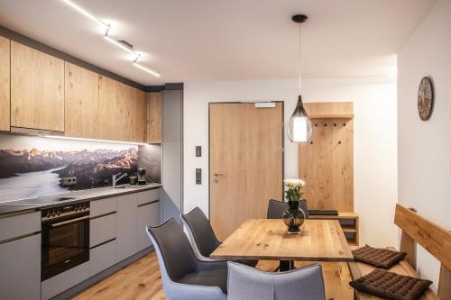 a kitchen and dining room with a wooden table and chairs at Huus123 in Au im Bregenzerwald