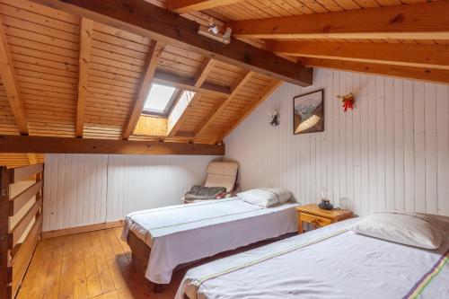 Cette chambre mansardée comprend 2 lits et une fenêtre. dans l'établissement Les Louveteaux, à La Bresse