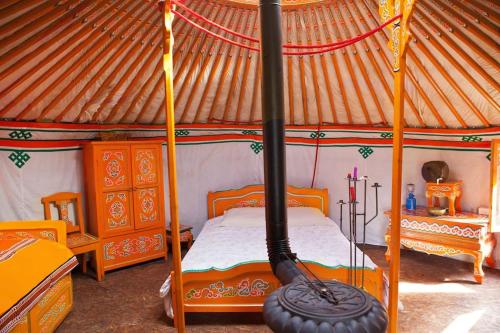 1 dormitorio con 1 cama en una yurta con una rueda grande en Le Bois Davy en Le Thoureil