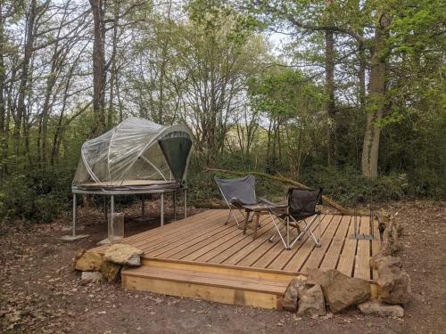 two chairs and a tent on a wooden deck at Le Bois Davy in Le Thoureil