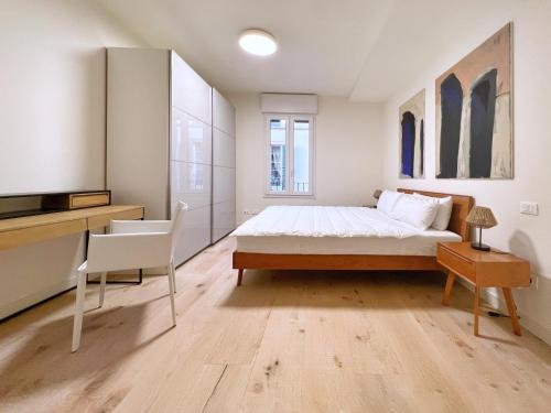 Schlafzimmer mit einem Bett, einem Schreibtisch und einem TV in der Unterkunft UR NEST San Giorgio in Bologna