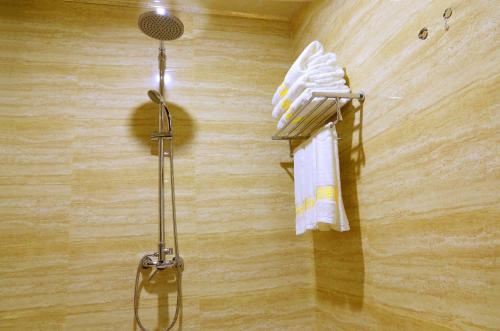 a shower with a rack with towels on a wall at Yabuli Hot Spring Health Center Hotel in Shangzhi