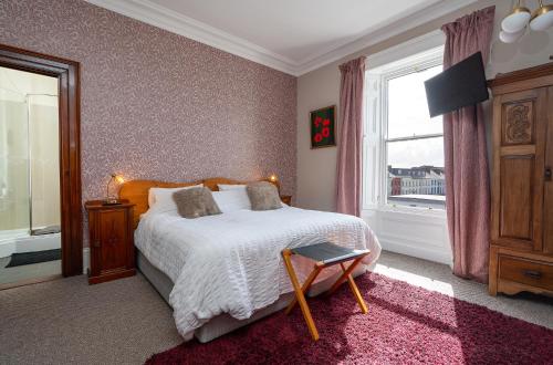a bedroom with a bed and a window at Antrim House Guest Rooms & Suites in Portrush