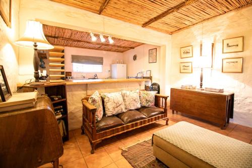 un soggiorno con un divano e un tavolo di Ironstone Cottage a Graaff-Reinet