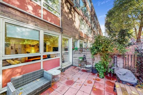 a building with a bench in front of a building at Charming 2-bedroom maisonette with private garden in London