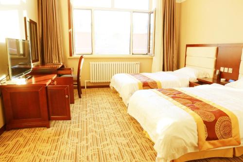 Habitación de hotel con 2 camas y TV en Yabuli Hot Spring Health Center Hotel, en Shangzhi