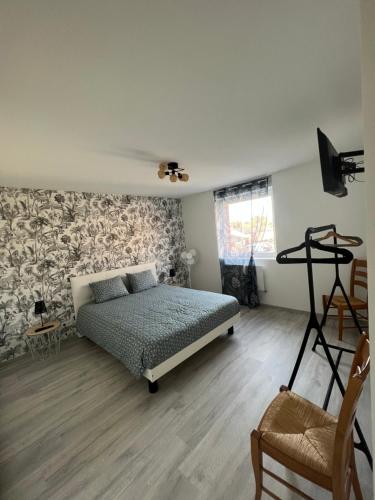 a bedroom with a bed in the middle of a room at Le Séjour qu'on M in Le Cateau