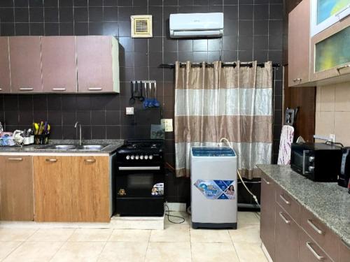a kitchen with a stove and a sink and a counter at Chez B&D Suites and Apartments in Abuja