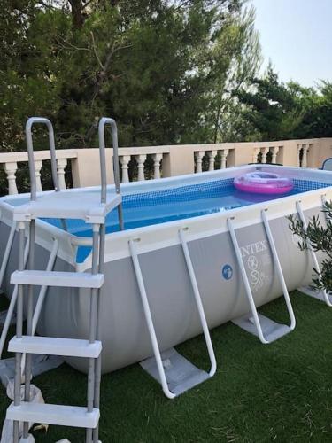 une piscine avec deux chaises, une table et un frisbee dans l'établissement La Maison des Délices, au Beausset