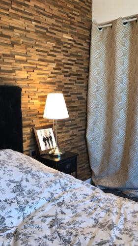 une chambre avec un lit et une lampe sur une table dans l'établissement La Maison des Délices, au Beausset