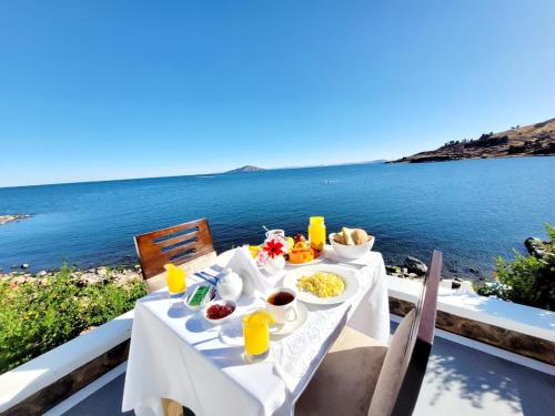 uma mesa branca com comida em cima do oceano em Amantani palace em Ocosuyo