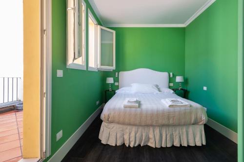 a green bedroom with a bed and green walls at Green House city center in Bologna