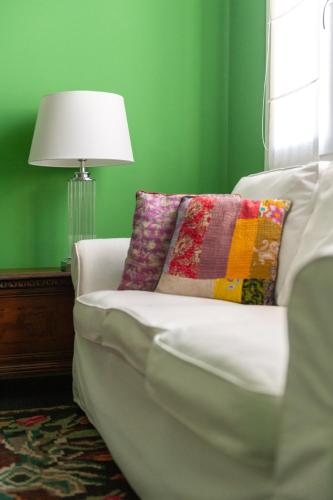 a living room with a white couch and a lamp at Green House city center in Bologna