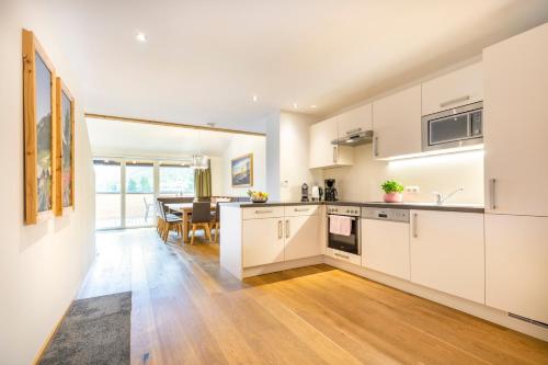 a kitchen with white cabinets and a dining room at Ferienanlage Central in Flachau