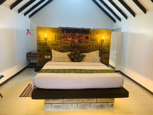 Outback Kenya Lodge في Machakos: غرفة نوم بسرير كبير في غرفة