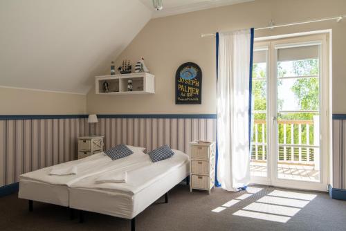 a bedroom with a bed and a large window at Dwór Złotopolska Dolina Mansion House in Trębki