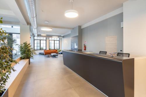an office lobby with a reception counter and plants at Camplus Regio Parco in Turin