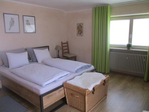 una camera con letto e finestra con tende verdi di Haus Schmauß - Chiemgau Karte a Inzell