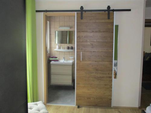 a bathroom with a sliding door with a sink at Haus Schmauß - Chiemgau Karte in Inzell